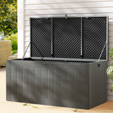 Gray outdoor storage box with black mesh lid on a wooden deck.